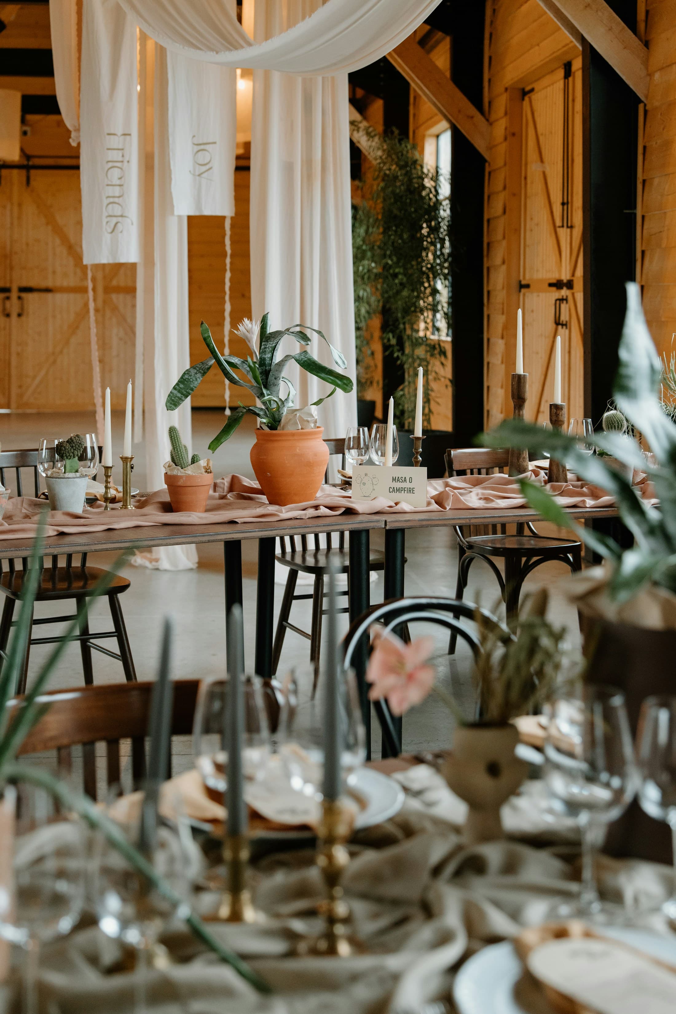A carefully styled table with candles, florals, and soft draping