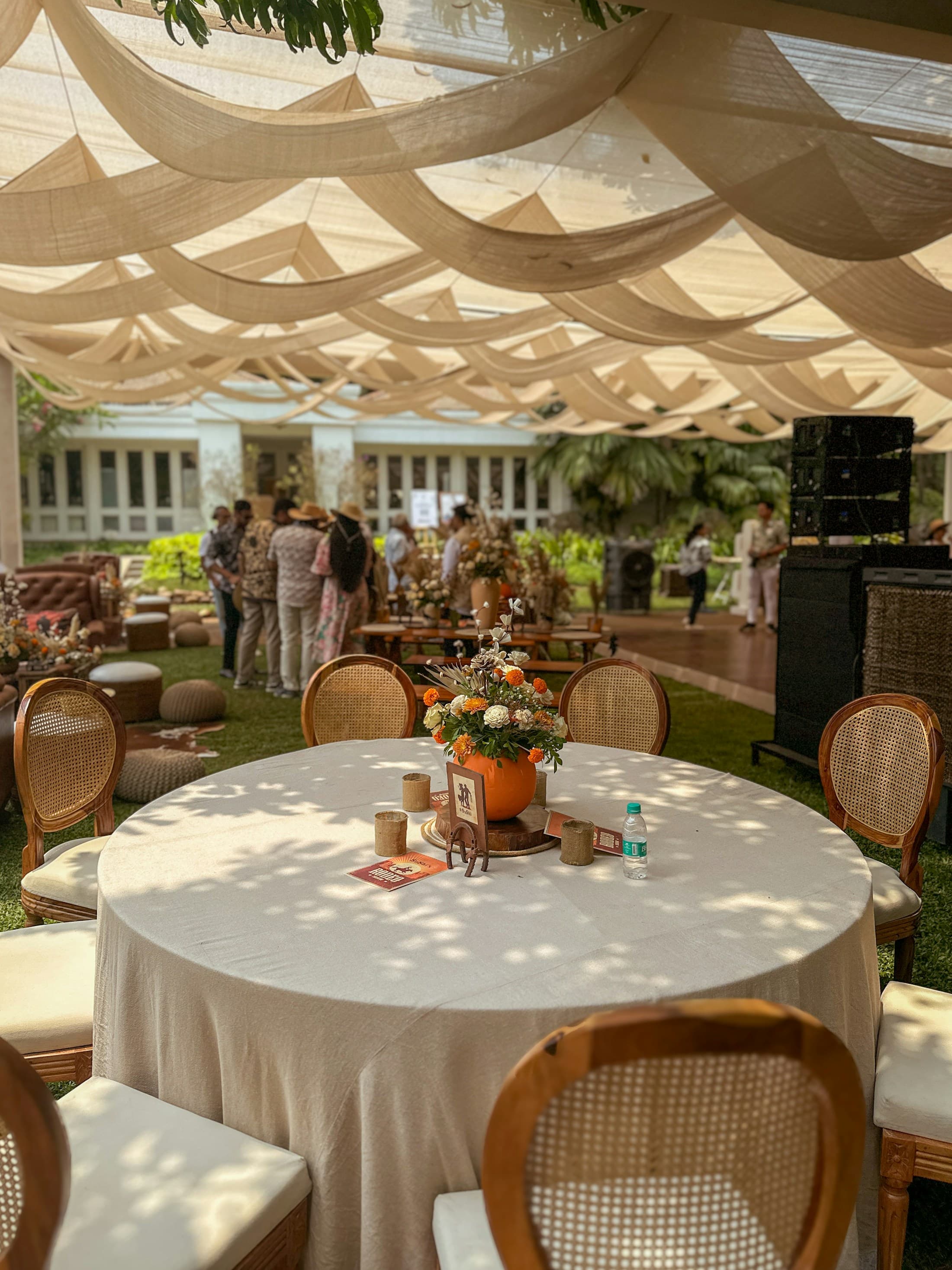 An outdoor lounge and dining setup under shade cloth